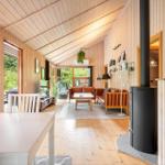Wohn- und Essbereich mit Holzwänden, Sofa und Kaminofen.