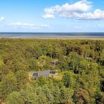 Haus im Wald mit Blick auf Meer und Himmel