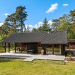 Modernes Haus mit Holzterrasse und Garten in Waldnähe.