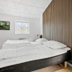 Schlafzimmer mit Bett, Fenster und Holzwand