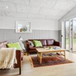 Wohnzimmer mit zwei Ledersofas, Holztisch und Terrassentür.