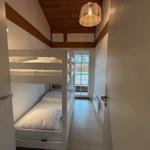 Zimmer mit Doppelstockbetten und Holzdecke