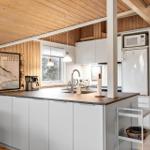 Kitchen with countertop, sink, and refrigerator. Bedroom visible in the background.
