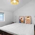 Bedroom with white mattress, window, and wall pictures.