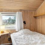 Bedroom with wooden walls, bed, window, and nightstand.