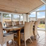 Dining room with wooden table, wicker chairs, and large window view.