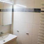 Badezimmer mit Waschbecken, Spiegelschrank und Heizkörper