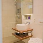 Badezimmer mit Dusche, Waschtisch und Toilette.
