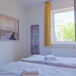 Schlafzimmer mit Bett, Fenster und Wandbild