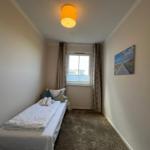 Schlafzimmer mit Bett, Fenster und Wandbild