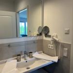 Badezimmer mit Waschbecken, Spiegel und Handtuchhalter