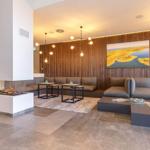 Wohnbereich mit Sofa, Kamin und Holzwand