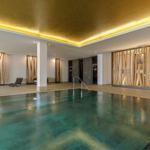 Indoorpool mit Holzverkleidung und goldfarbenem Deckenlicht.