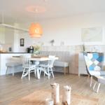 Küche, Essbereich und Wohnzimmer mit Holzboden und moderner Einrichtung.