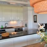 Küche mit weißen Schränken, Edelstahlgeräten und Holzoberflächen.