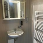 Badezimmer mit Waschbecken, Spiegelschrank und Heizkörper