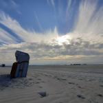 Strand mit Strandkorb und dramatischem Himmel