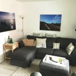 Ein Wohnzimmer mit einem dunklen Sofa, zwei Wandbildern und einem Couchtisch.