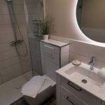 Badezimmer mit Dusche, Waschbecken und Toilette.