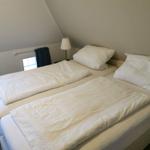 Zimmer mit Doppelbett, Fenster und Nachttisch