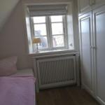 Schlafzimmer mit Bett, Fenster und Kleiderschrank