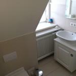 Badezimmer mit Waschbecken, Spiegel und Fenster