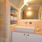 Badezimmer mit Dusche, Waschbecken und Handtüchern
