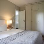 Schlafzimmer mit Bett, Nachttisch und Kleiderschrank.