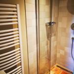 Dusche mit Glaswand und Heizkörper an der Wand
