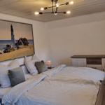 Schlafzimmer mit Bett, Wandbild und Schrank.