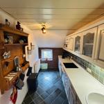 Küche mit Holzregal, Arbeitsplatte und Fenster