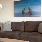 Ein braunes Sofa mit Kissen und einer Wanddekoration über dem Sofa.