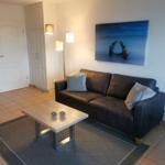 Wohnzimmer mit Sofa, Couchtisch und Wandbild.