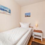 Ein Schlafzimmer mit einem Bett, Nachttisch und Wandbildern.