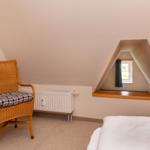 Schlafzimmer mit Dachschrägen, Stuhl und Fenster
