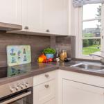 Küche mit Arbeitsfläche, Spüle und Fensterblick auf Garten