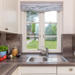 Küche mit Fenster, Spüle und Obst auf Arbeitsfläche