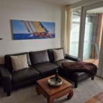 Wohnzimmer mit Sofa, Couchtisch und Blick auf die Terrasse.