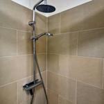 Dusche mit Duschbrause und Handbrause an der Wand