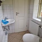 Badezimmer mit Waschbecken, Toilette und Fenster