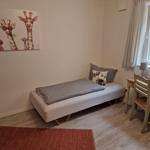 Schlafzimmer mit Bett, Schreibtisch und Wandbild mit Giraffen.