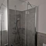Dusche mit Glaswand und Duschbrause