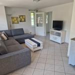 Wohnzimmer mit Sofa, Fernseher und Tisch