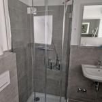 Bad mit Dusche, Waschbecken und Spiegel