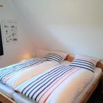 Zimmer mit Doppelbett, Fenster und Wandposter.