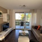 Living room with sofa, TV, and balcony view.
