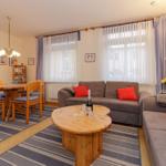 Wohn- und Essbereich mit Sofa, Tisch und Stühlen.