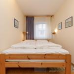 Ein Schlafzimmer mit einem Doppelbett, weißen Bettwäsche und einem Fenster mit Vorhängen.
