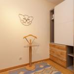 Schlafzimmer mit Kleiderständer, Schrank und Wanddekoration.