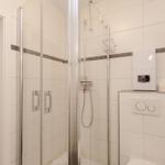 Dusche mit Glaswand, Toilette und Spiegelschrank